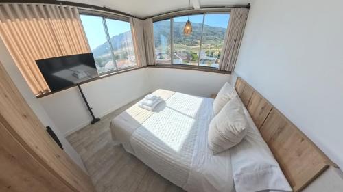 a bedroom with a bed in a room with windows at Mirasierra in Mancha Real