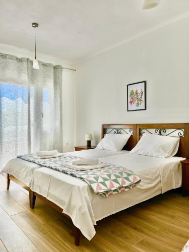 a bedroom with two beds and a large window at Πράσινο σπιτάκι in Kastoria