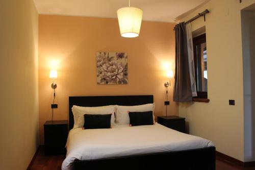 a bedroom with a bed with two night stands and two lamps at Guest House La Selvotta in Formello