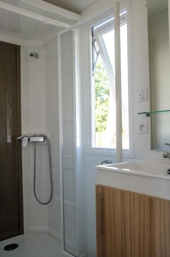 a bathroom with a shower and a sink and a window at Cap Océan in Seignosse