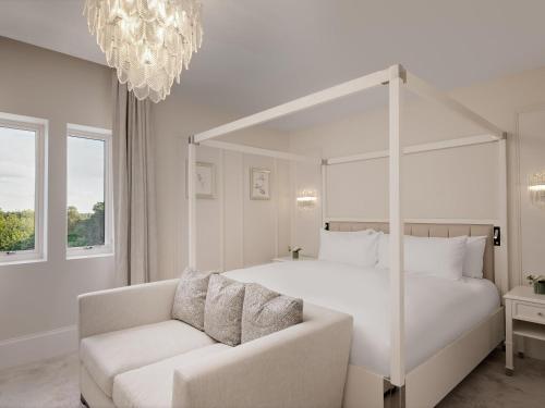 a white bedroom with a bed and a couch at Fairmont Windsor Park in Windsor