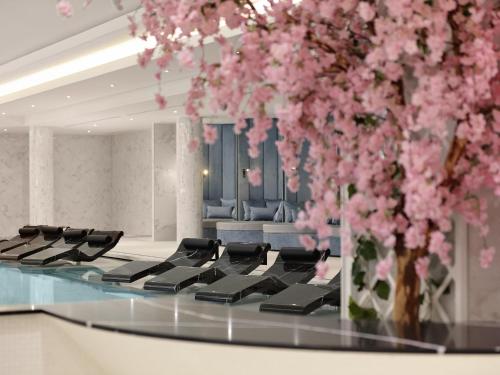 a room with a piano with pink flowers in it at Fairmont Windsor Park in Windsor