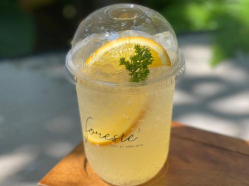a drink in a plastic cup with an orange slice at Anna-Nava Pakkret Hotel in Nonthaburi