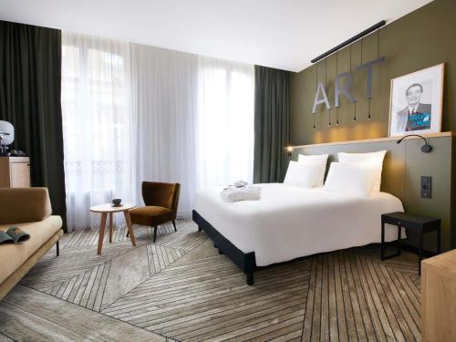 a hotel room with a large bed and a couch at Mercure Grand Hôtel Metz Centre Cathédrale in Metz