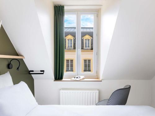 a bedroom with a bed and a window at Mercure Grand Hôtel Metz Centre Cathédrale in Metz