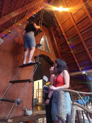 a man standing on a ladder in a room with a woman at Sigiri Hunter's Eco Tree lodge in Sigiriya