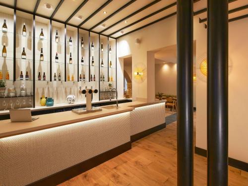 a bar with a display of wine bottles at Mercure Grand Hôtel Metz Centre Cathédrale in Metz
