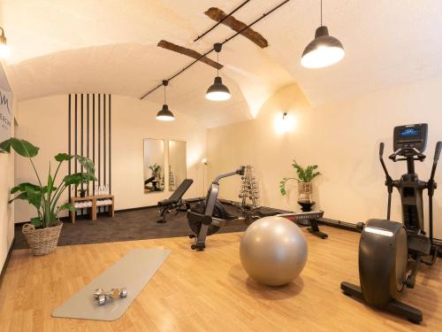 a gym with exercise bikes and a ball on the floor at Mercure Grand Hôtel Metz Centre Cathédrale in Metz