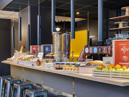 a bakery counter with a bunch of food on it at ibis Clamart Paris Velizy in Clamart