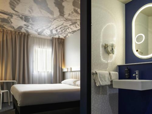 a hotel room with a bed and a sink at ibis Clamart Paris Velizy in Clamart