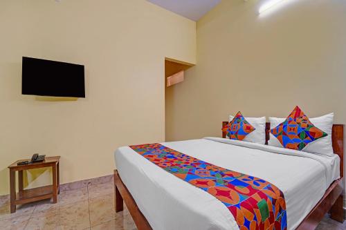 a bedroom with a bed and a flat screen tv at FabHotel Martines Residency in Puducherry