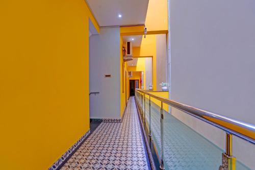 a hallway with yellow walls and a metal railing at FabHotel Martines Residency in Puducherry