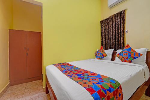 a bedroom with a bed with a colorful comforter at FabHotel Martines Residency in Puducherry