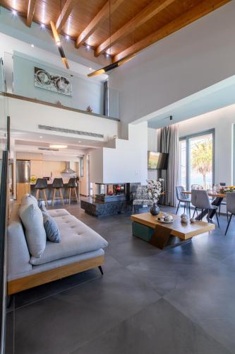 a living room with a couch and a table at Superior Villa Kleanthi in Stalos