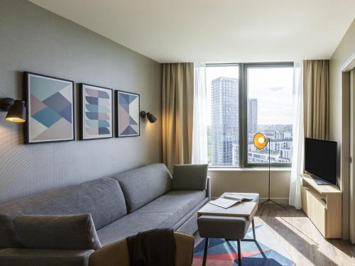 a living room with a couch and a tv at Aparthotel Adagio London Stratford in London