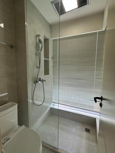 a bathroom with a shower and a toilet and a glass shower stall at A Homestay in Zhongxingchang