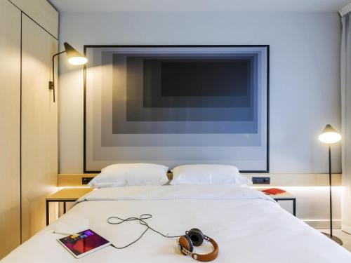a bedroom with two beds and a tv on the wall at ibis Timisoara City Center in Timişoara