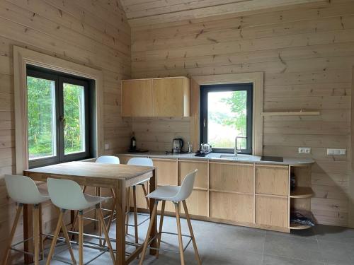 a kitchen with wooden walls and a wooden table and chairs at Sikana Mõisa saun in Sikana