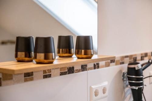 a row of five cups on a counter in a kitchen at Wohnung Staufenblick in Freilassing