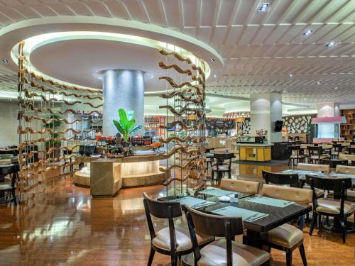 a dining room with tables and chairs in a restaurant at Pullman Foshan Shunde-Canton Fair Shuttle Bus at Extra RMB100 per Person Daily in Shunde