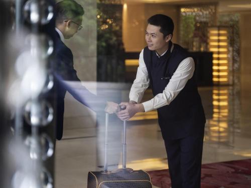 a man is cutting a cake in front of a table at Pullman Foshan Shunde-Canton Fair Shuttle Bus at Extra RMB100 per Person Daily in Shunde