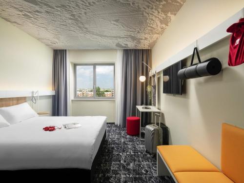 a hotel room with a large bed and a window at ibis Bucharest Politehnica in Bucharest