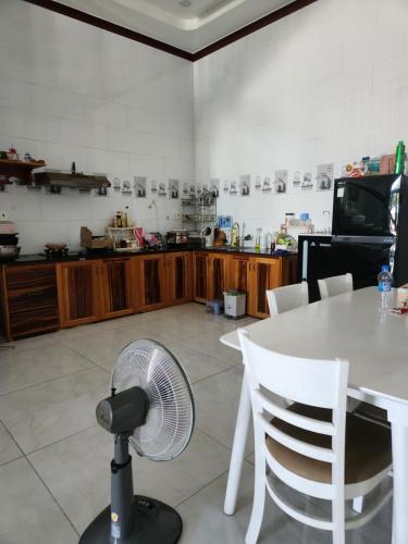 a room with a table with a fan and a kitchen at Biển homestay in Phan Rang