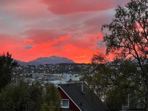 a sunset over a city with a mountain in the background at Tromsø pearl near mountains, city life and northern lights in Tromsø
