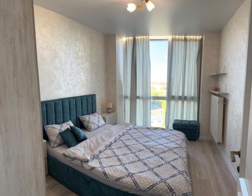 a bedroom with a large bed with a large window at Апартаменти Промінь ЖК яровиця Луцьк in Luts'k