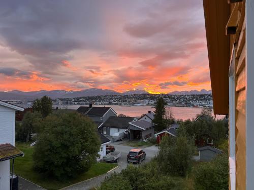 a view of a sunset from a residential neighborhood at Tromsø pearl near mountains, city life and northern lights in Tromsø