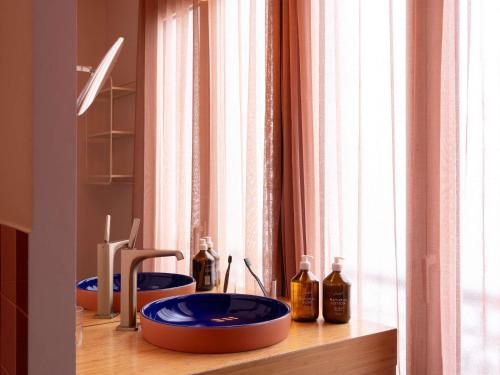 a bathroom with two blue bowls on a wooden counter at 25hours Hotel Terminus Nord in Paris