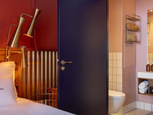 a blue door in a room with a toilet at 25hours Hotel Terminus Nord in Paris