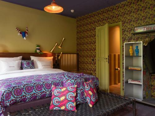 a bedroom with a large bed with colorful pillows at 25hours Hotel Terminus Nord in Paris