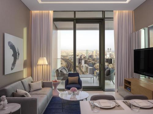 a living room with a couch and a tv at SLS Dubai Hotel & Residences in Dubai