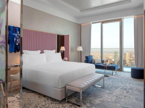 a bedroom with a large white bed and a large window at SLS Dubai Hotel & Residences in Dubai