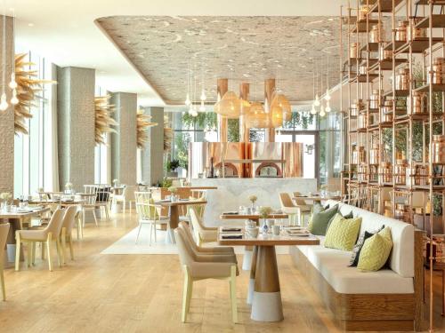 a dining room with tables and chairs and a restaurant at SLS Dubai Hotel & Residences in Dubai