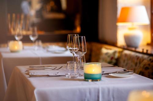 a table with wine glasses and a candle on it at Appartements by Romantik Hotel zur Sonne in Badenweiler