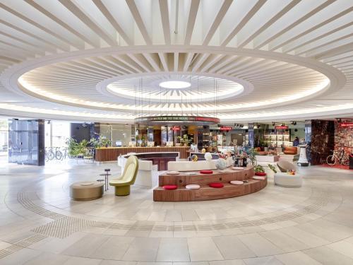 a lobby of a shopping mall with a large ceiling at 25hours Hotel The Circle in Cologne