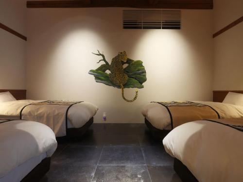 a room with three beds and a painting of a pineapple at 湯の里いけもり別館 天座 in Himi
