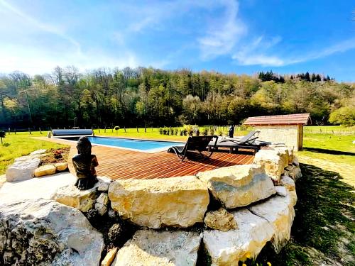 a stone retaining wall next to a swimming pool at Domaine de la Papeterie in Glay