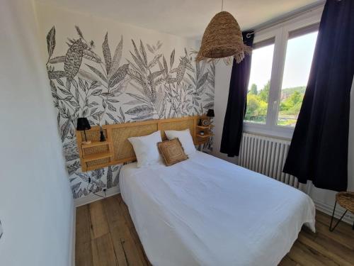 a bedroom with a white bed with a plant wallpaper at La petite Compiégnoise in Margny-lès-Compiègne
