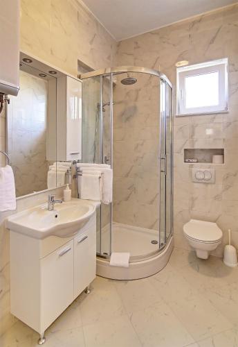 a bathroom with a shower and a sink and a toilet at Vista Apartments in Cavtat