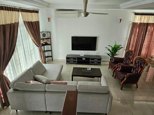 ein Wohnzimmer mit Sofa und Fernseher in der Unterkunft Leisure Homestay BM in Bukit Mertajam