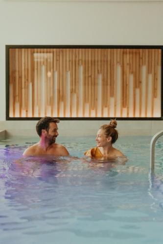 ル・クードレイ・モンソーにあるDemeures de Campagne Parc du Coudray - Barbizonのスイミングプールの男女