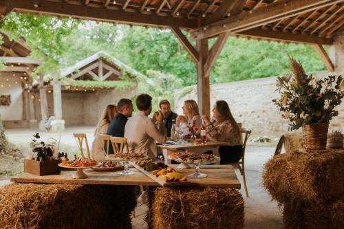 ル・クードレイ・モンソーにあるDemeures de Campagne Parc du Coudray - Barbizonの食べ物を持ってテーブルに座っている人々のグループ