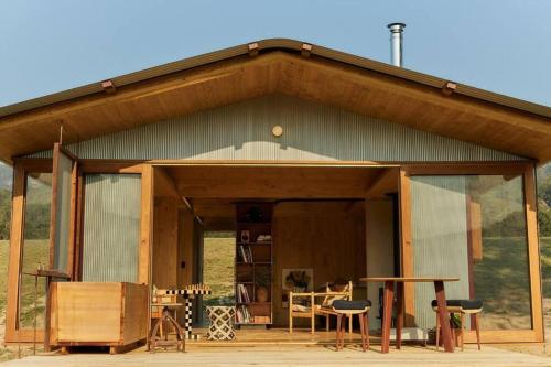 a small house with glass doors and a table at Dimensions X Farm-stay at Krinklewood Estate in Broke