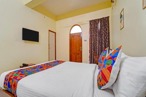 a bedroom with a bed and a window and a television at FabHotel Martines Residency in Puducherry