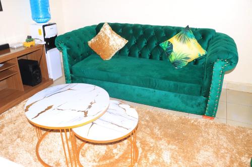 a green couch with two tables in a living room at Blissful one bedroom in Ruiru in Ruiru