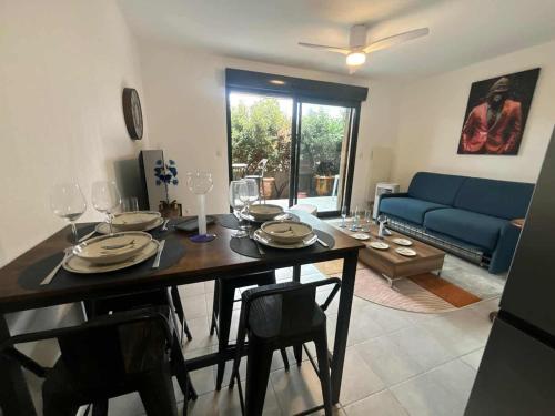 ナルボンヌにあるComfortable ground floor apartment - terrace - parkingのテーブルと青いソファのあるリビングルーム