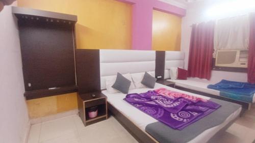 a bedroom with a bed with a purple blanket on it at Hotel M India Dx- NEAR NEW DELHI RAILWAY STATION in New Delhi